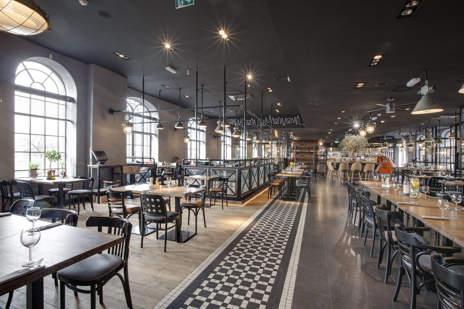Sala restauracyjna — drewniane stoły, lampy industrialne